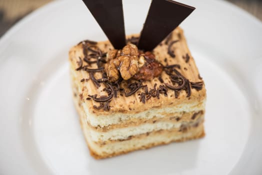 Walnut and chocolate cake on white plate
