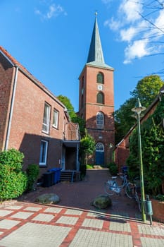 Esens,Germany - October 5,2016: View through a small alley to the tower of St. Magnus Church in Esens / East Frisia.