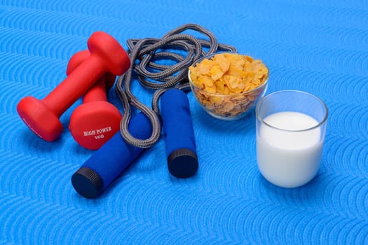 Sports fitness accessories on blue training mat. Frame, healthy.