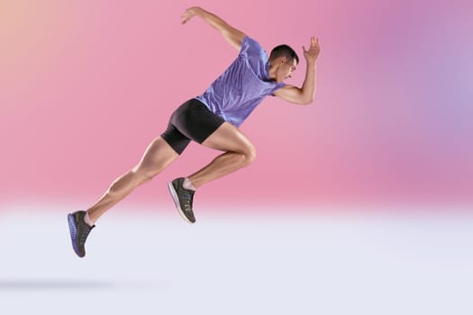The studio shot of high jump athlete is in action on pink background