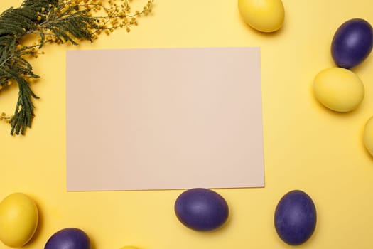Beautiful easter table setting composition. A row of lilac and yellow color eggs on yellow background. Happy Easter greeting card. Top view, copy space.