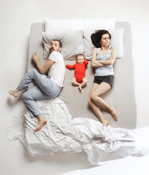 Top view of happy funny family with one newborn child in bedroom. Enjoying being together. Happy family in bed. Top view. Emotions concept. Morning after sleep. Family lifestyle. happy parents concept