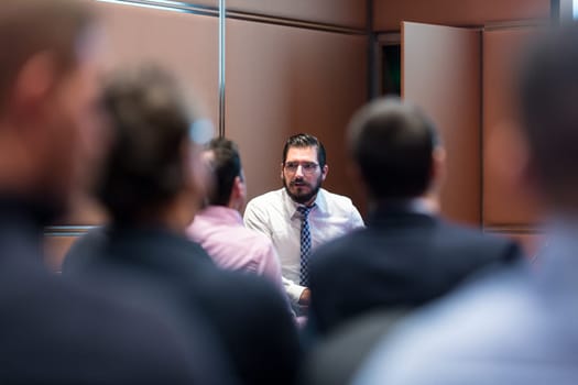 Skiled businessman presenting project to his work team at informal company business training meeting. Business people in the conference room. Business and Entrepreneurship concept.