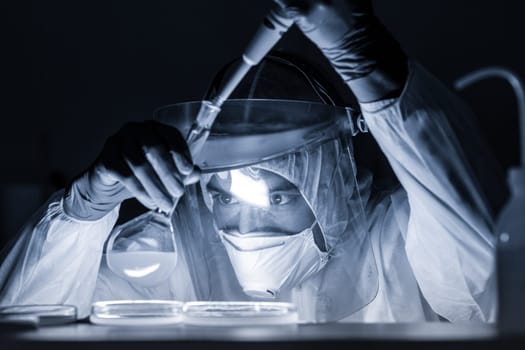 Life scientist researching in bio hazard laboratory. Focused life science professional working on experiment in high protection degree work laboratory. Healthcare and biotechnology.