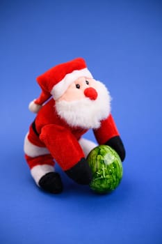 little santa claus with green easter egg on blue ground