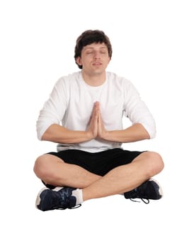 An Caucasian young handsome man sitting on the floor in the studio with his.legs crossed and eye closed in yoga, isolated for white background.