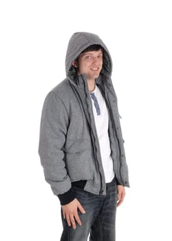 Handsome young man standing halve length in a gray jacket with a hoody and.jeans, isolated for white background.