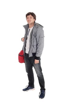 A handsome young Caucasian man standing in a gray jacket with his gym.back over his shoulder, isolated for white background.