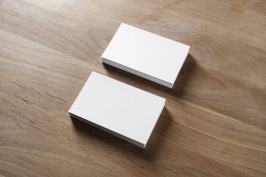 Mockup of two horizontal business cards stacks on wood background.