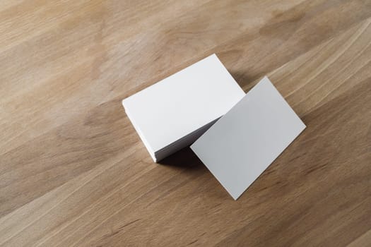 Blank business cards on wood background. Mockup for branding identity.