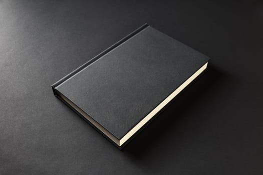 Blank book cover on black paper background.