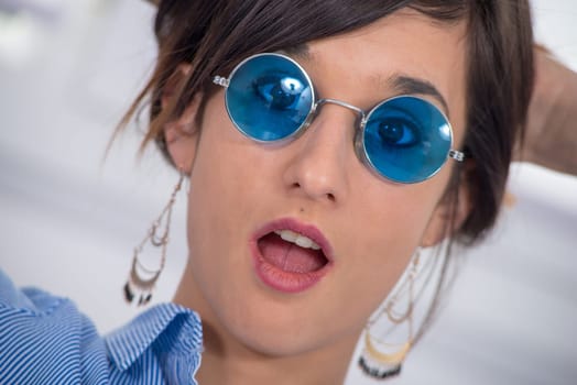 a beautiful young brunette woman with blue glasses