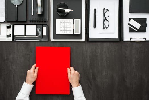 Corporate businessman working at office desk, he is holding a folder, business and finance concept, flat lay