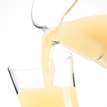 Pouring refreshing apple or lemon juice in a glass, healthy drinks concept