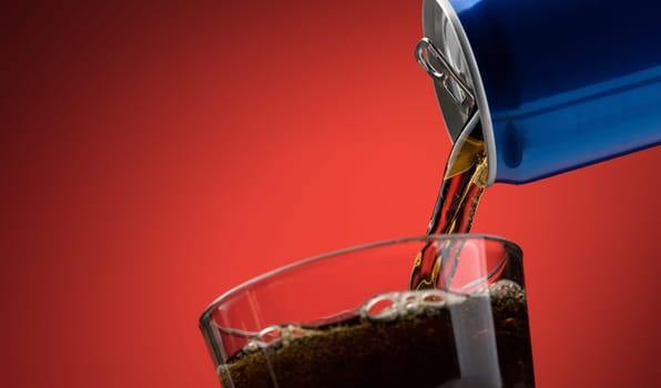 Pouring a refreshing sugary soft drink from a can into a glass