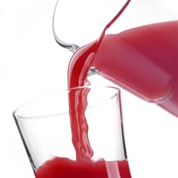 Pouring delicious pomegranate juice in a glass, healthy drinks concept