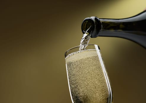 Pouring white wine from a bottle into a wineglass: celebration and wine tasting