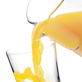 Pouring refreshing orange or pineapple yellow juice in a glass, healthy drinks concept