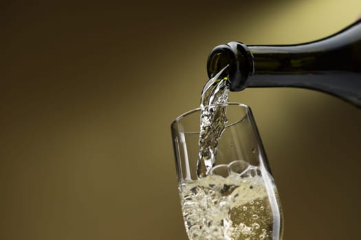 Pouring white wine from a bottle into a wineglass: celebration and wine tasting