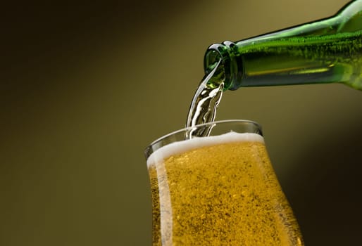 Pouring fresh beer from a bottle into a glass, alcoholic drinks and celebration concept