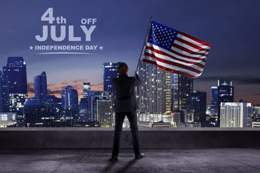 Businessman holding american flag on the terrace building. Happy Independence Day