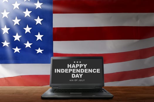 Laptop on desk with Happy Independence day sign in the screen. Happy Independence day