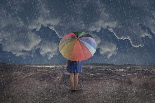 Rear view of asian woman with umbrella at rain on the dry land