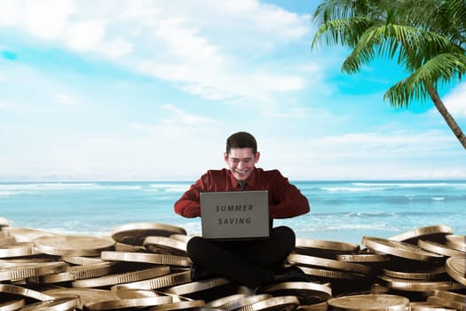 Handsome asian businessman with laptop sitting on coin stacks. Summer saving concept