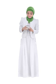 Portrait of asian muslim woman using mobile phone posing isolated over white background