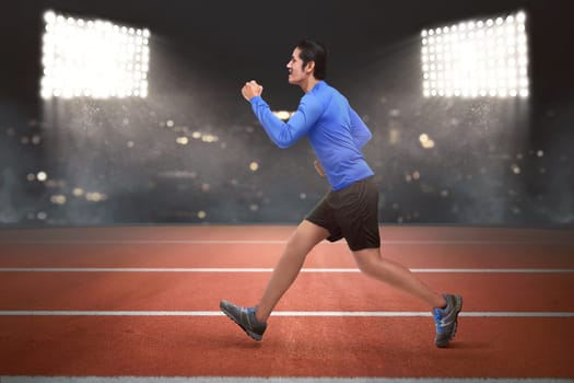 Young asian runner man running on the race track