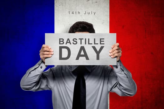 Man holding board with bastille day message over france color flag background