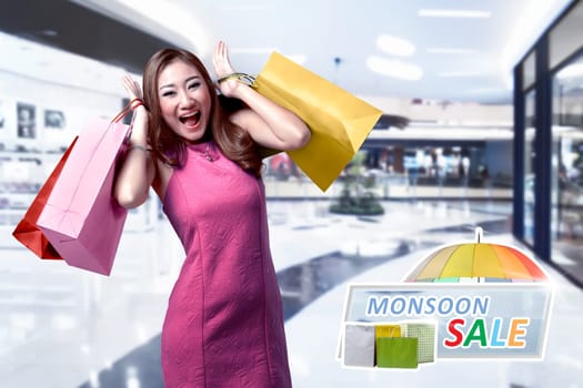 Pretty asian woman with colorful paper bag on the shopping mall. Monsoon sale concept