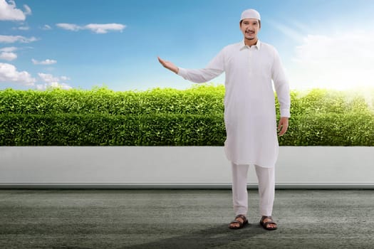 Handsome asian muslim man with traditional dress on the park