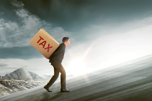 Attractive asian businessman bring the cardboard of TAX. Taxation concept