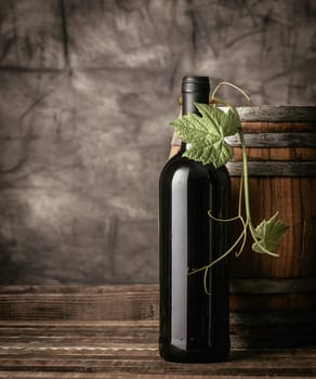 Red wine bottle, vine leaf and wooden barrel in the cellar, traditional wine making and tasting concept