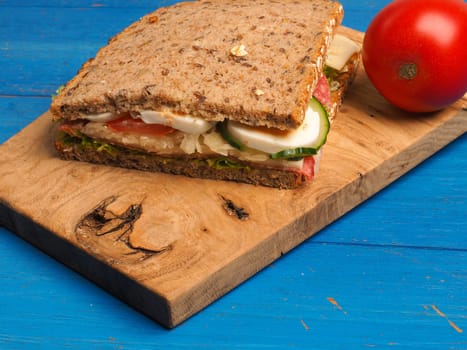 Tasty whole grain sandwich on a blue kitchen table, healthy eating cocnept
