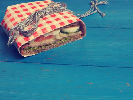 Tasty whole grain sandwich on a blue kitchen table, healthy eating cocnept