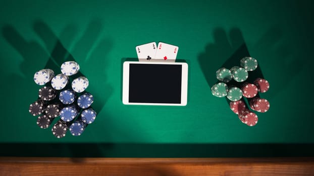 Online poker game app concept with digital tablet, cards and stacks of chips, top view