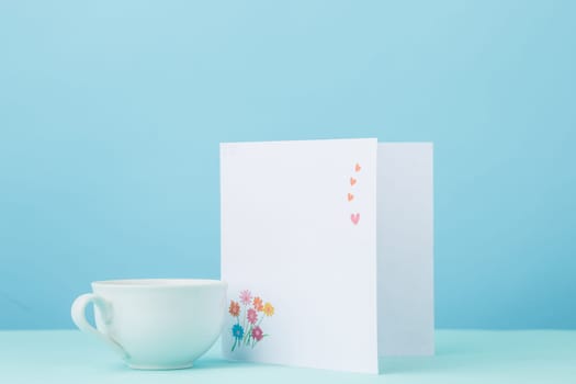 Love background with card and cup of coffee on table. Concept of holiday Mother's Day. Copy space. Colorful studio background. holiday congratulations concept. Mother and love. Postcard