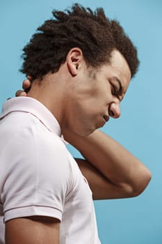 Pain concept. Beautiful male portrait isolated on pink backgroud. Young emotional afro man. Human emotions, facial expression concept. man overwhelmed with pain in the neck. Profile