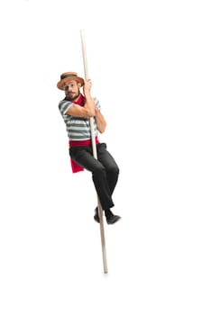 Caucasian funny bearded man in traditional gondolier costume and hat hanging on paddle at studio isolated on white background. discouraged young man. Human emotions, facial expression concept