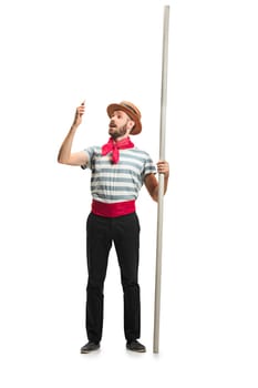 Caucasian funny bearded man in traditional gondolier costume and hat with paddle standing with mobile phone at studio isolated on white background. young man. Human emotions, facial expression concept