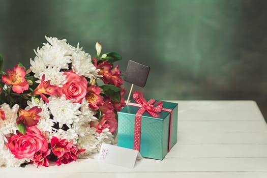 Love background with pink roses, flowers, gift, card on table. Concept of holiday Mother's Day. Copy space. Colorful studio background. holiday congratulations concept. Mother and love. Postcard