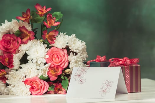Love background with pink roses, flowers, gift, card on table. Concept of holiday Mother's Day. Copy space. Colorful studio background. holiday congratulations concept. Mother and love. Postcard