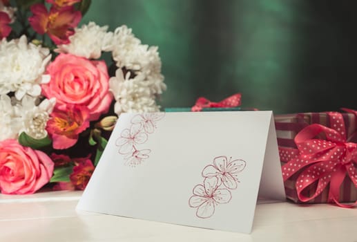 Love background with pink roses, flowers, gift, card on table. Concept of holiday Mother's Day. Copy space. Colorful studio background. holiday congratulations concept. Mother and love. Postcard