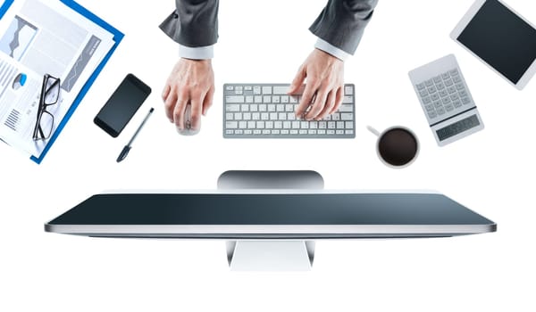 Executive businessman working on his computer at office desk, white background, hands top view