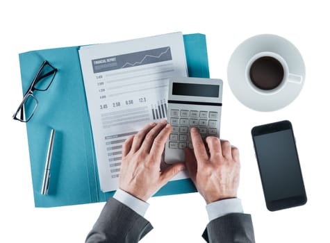 Professional businessman at desk checking a financial report and using a calculator