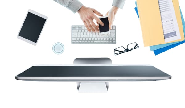 Businessman working at office desk and using an app on a touch screen smartphone, hands top view, white background