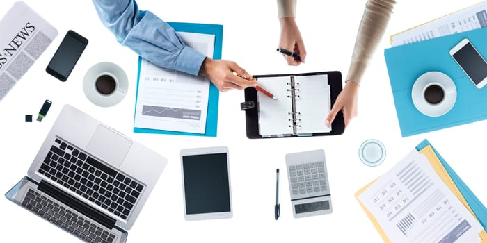 Business team checking appointment schedules on organizer's pages, unrecognizable people