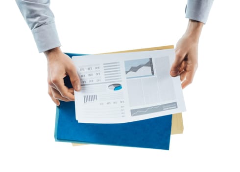 Businessman reading a financial report with charts and graphs on white background, hands close up, top view